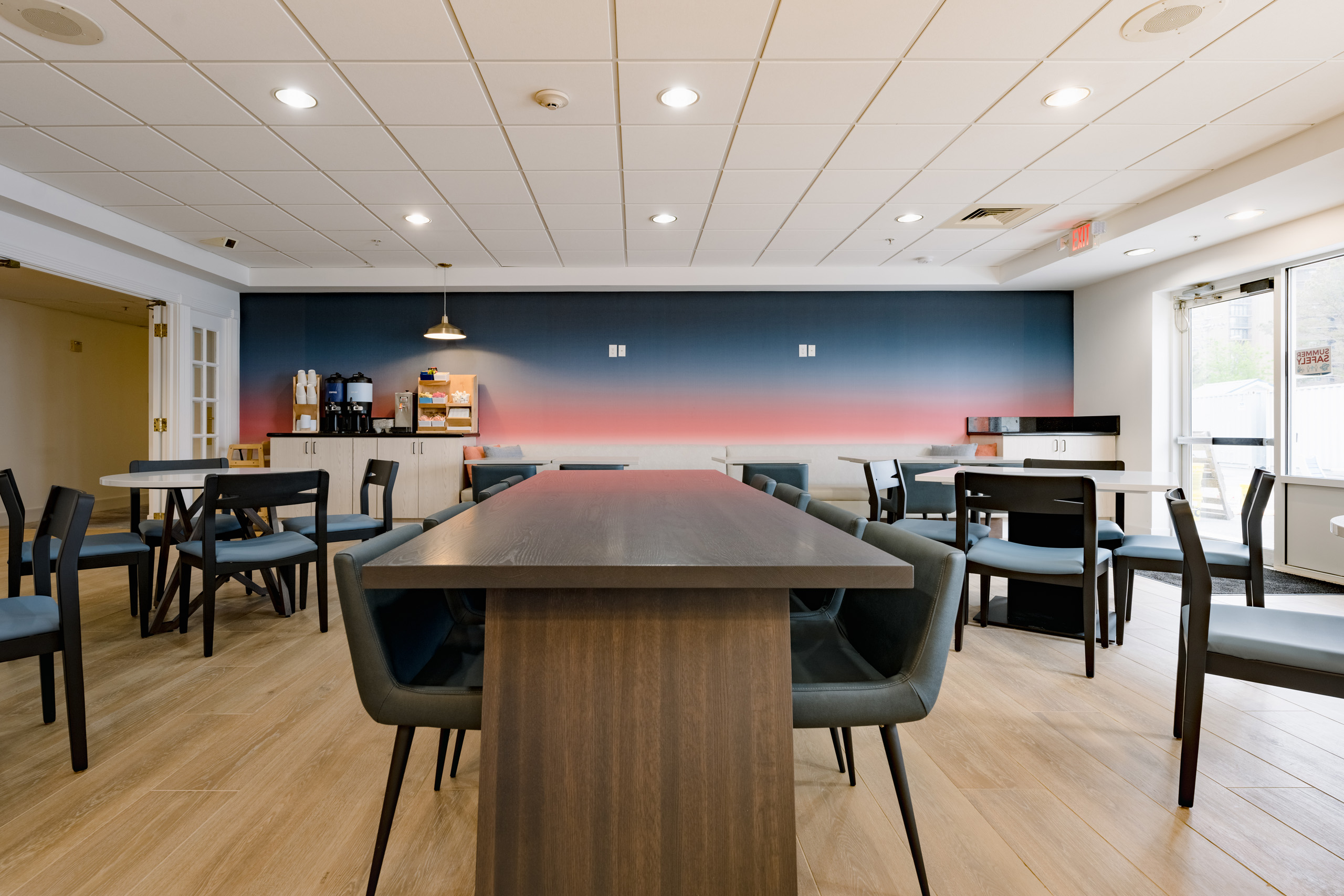 Breakfast area with modern tables, chairs, and coffee station.