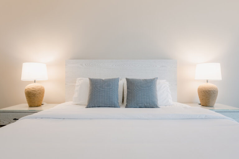 King bed with matching lamps and gray pillows.