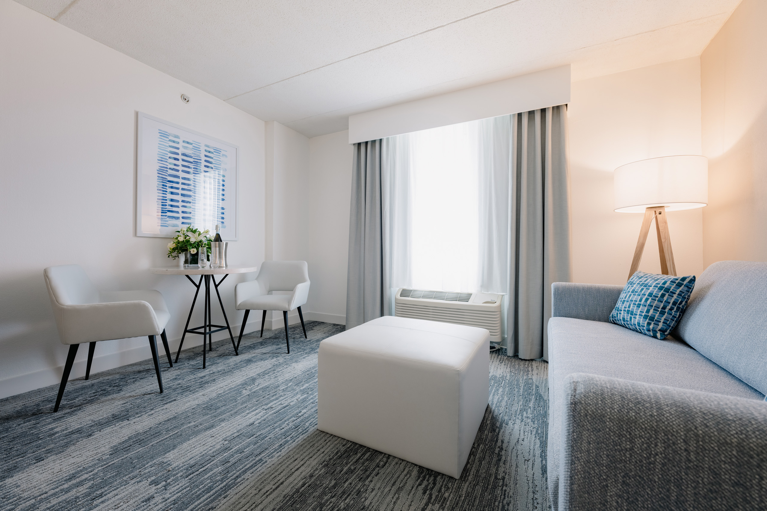 Hotel sitting area with sofa, table, and chairs.