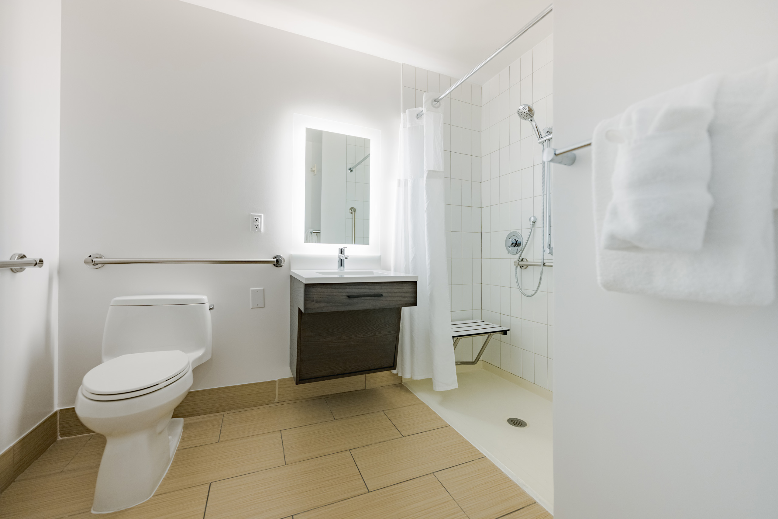 Accessible bathroom with walk-in shower and grab bars.