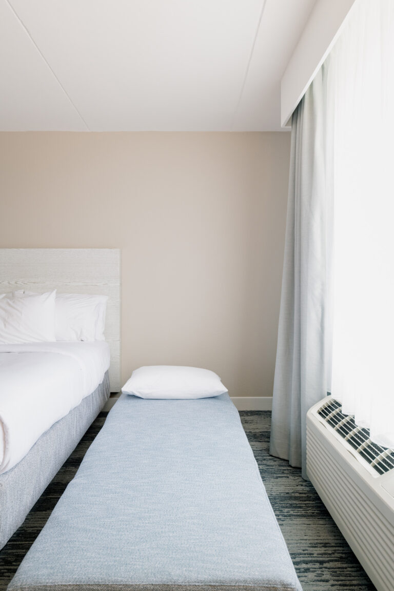 Folded-out sleeper chair with pillow near window.