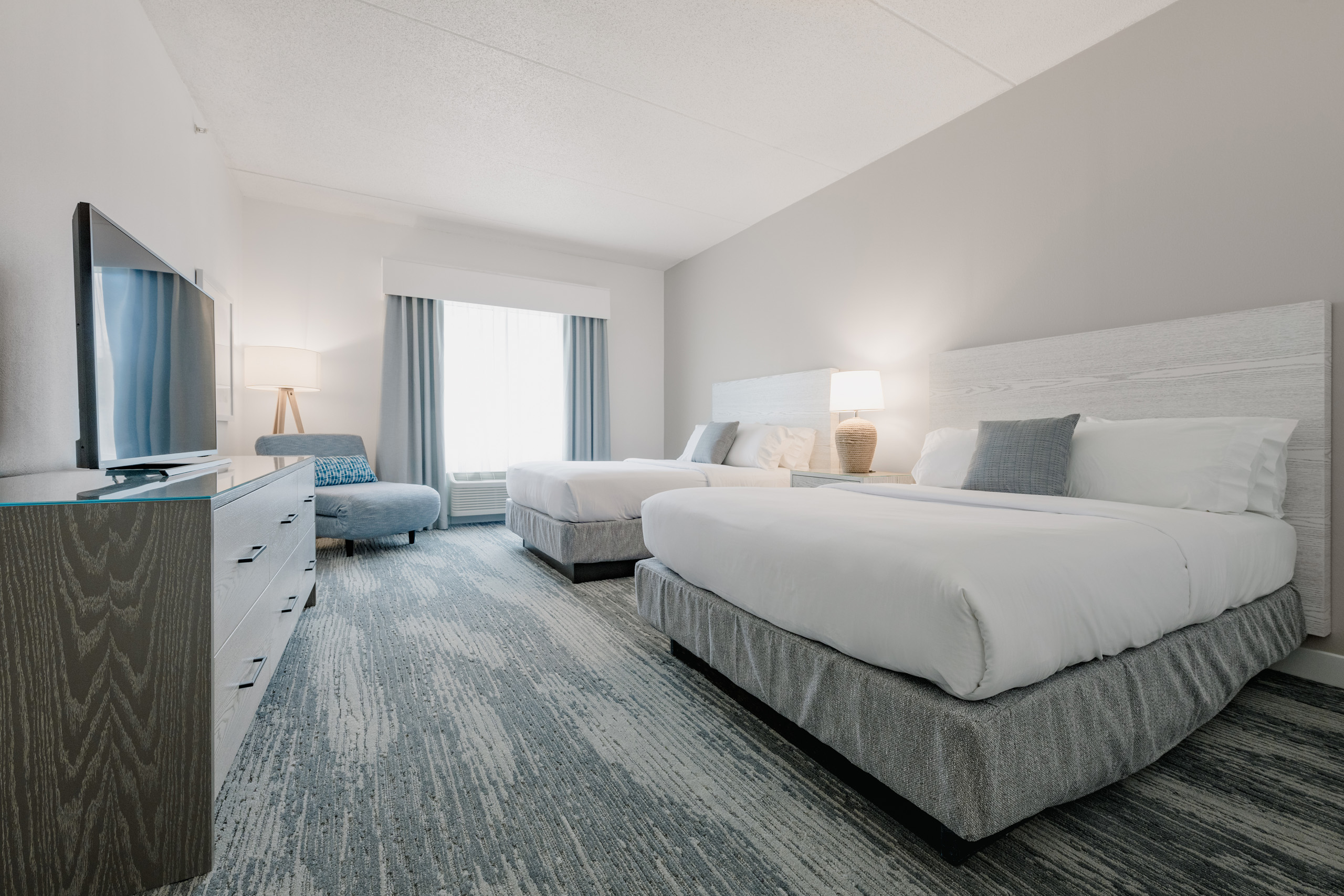 Two-queen accessible room with TV and wall mirror.