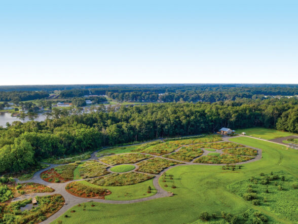 Aerial view of landscaped park surrounded by forest.