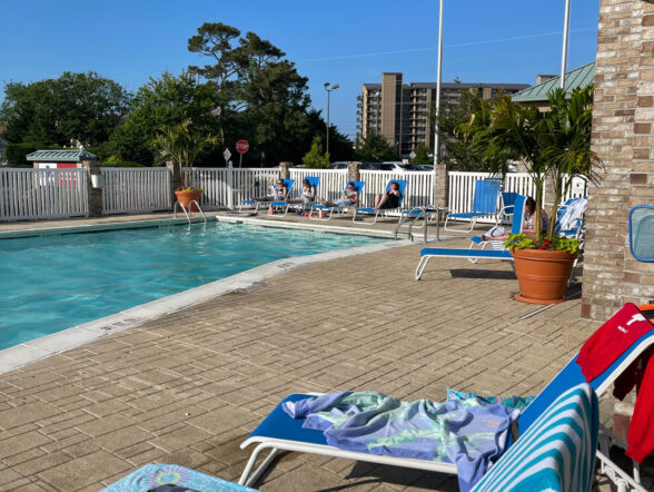 Outdoor pool with lounge chairs and towels.