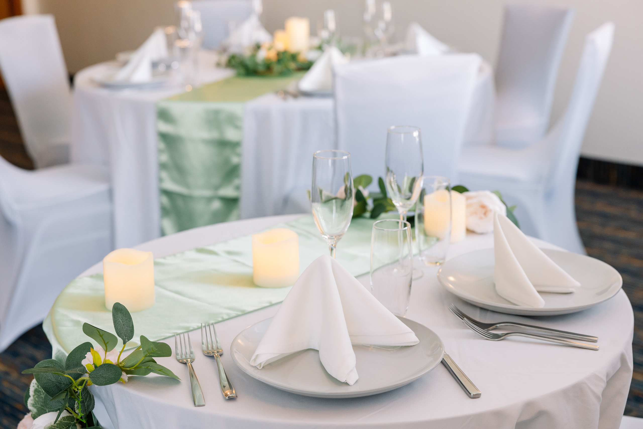 Close-up of table setting with candles and napkins.