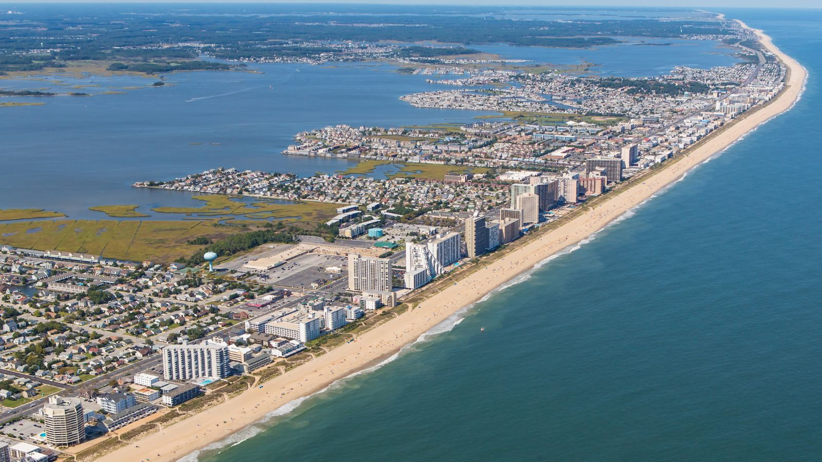Aerial view of coastal city with beachfront hotels and ocean.